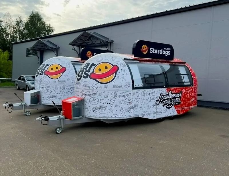Два фудтрака Aformer в белой и красной графике Stardogs у здания завода